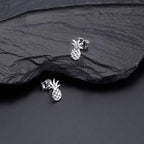 Flat Pineapple Stud Earrings in Sterling Silver on rocks