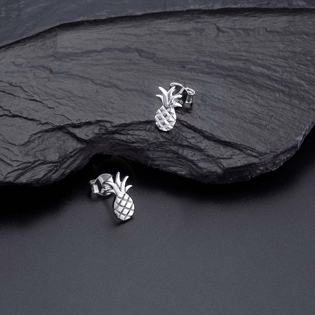 Flat Pineapple Stud Earrings in Sterling Silver on rocks