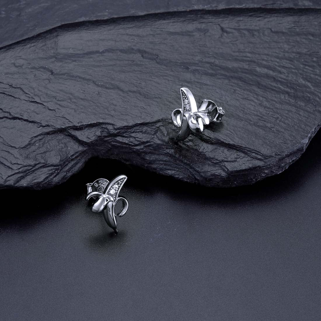 Banana Stud Earrings with Cubic Zirconia in Sterling Silver on rocks
