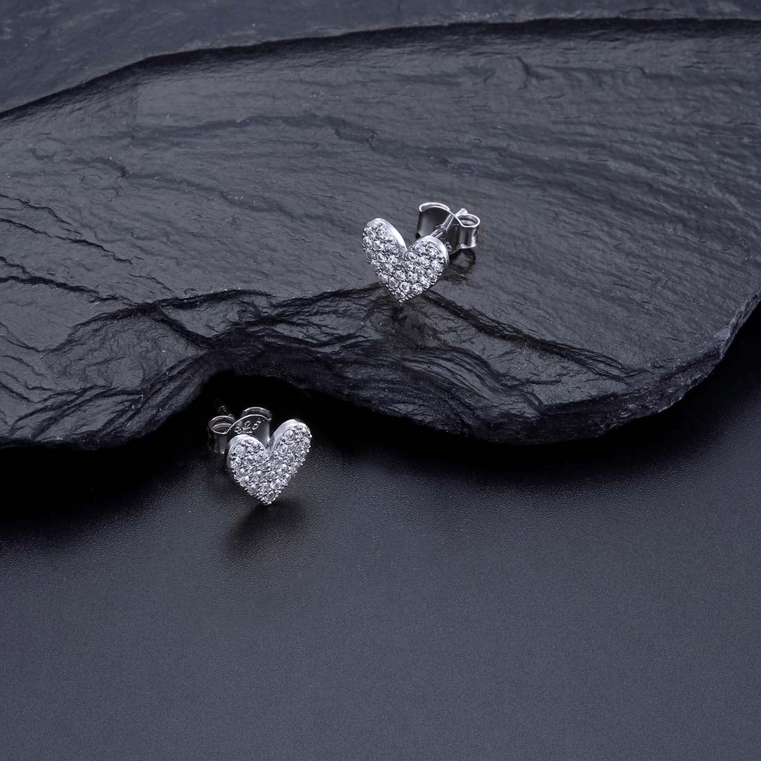Pave Heart Stud Earrings with Cubic Zirconia in Sterling Silver on rocks
