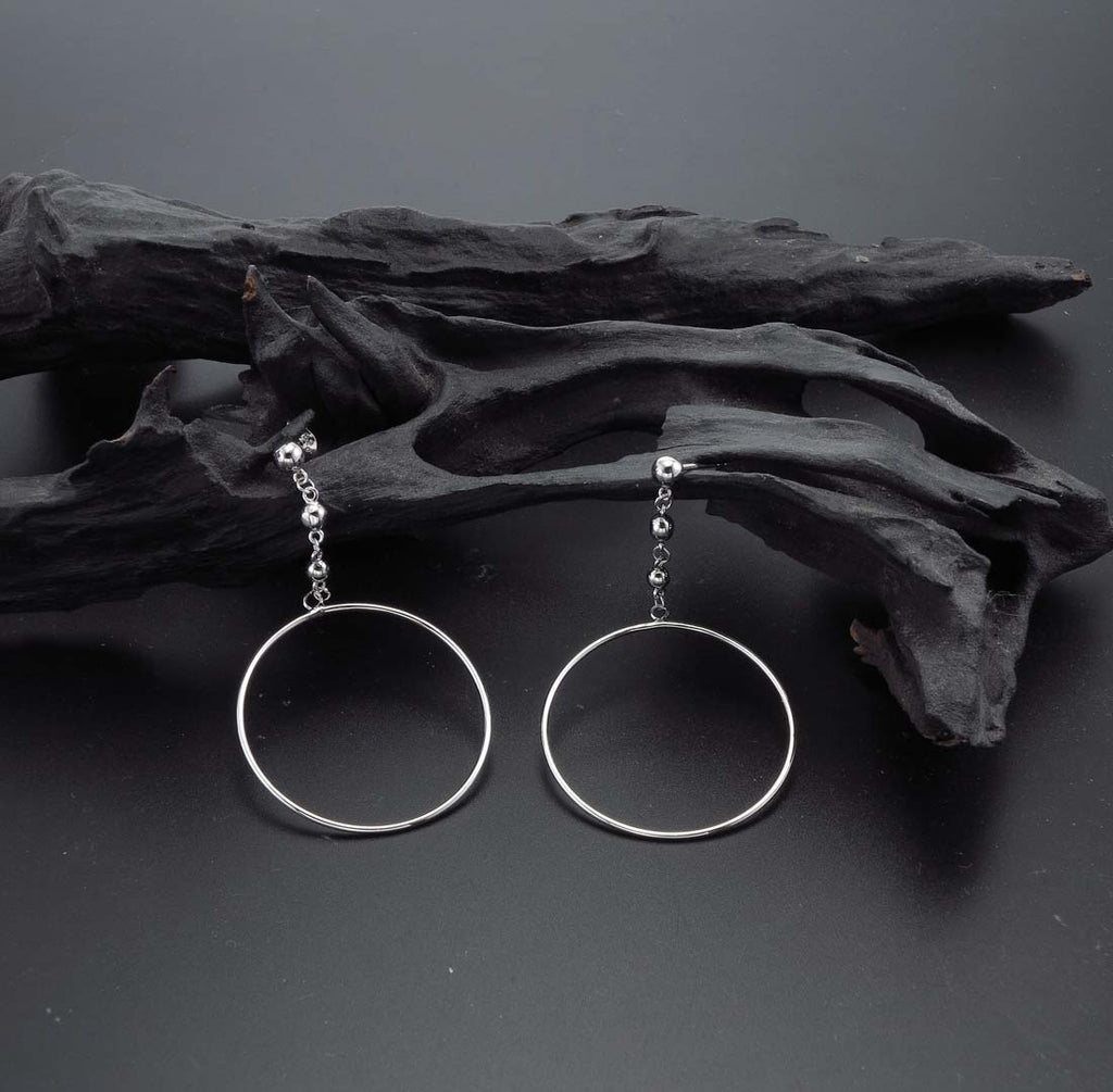 Hanging Circle Earrings in Sterling Silver on rocks