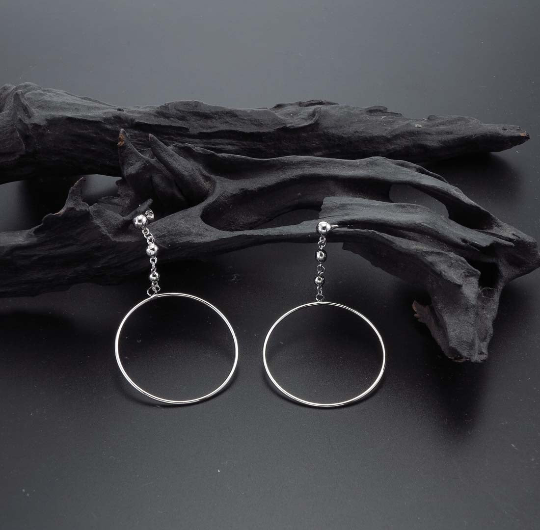 Hanging Circle Earrings in Sterling Silver on rocks