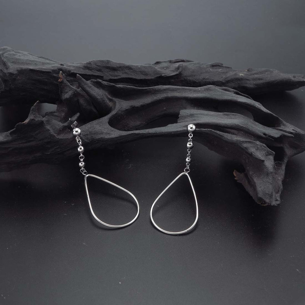 Hanging Pear Drop Earrings in Sterling Silver on rocks