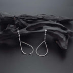 Hanging Pear Drop Earrings in Sterling Silver on rocks