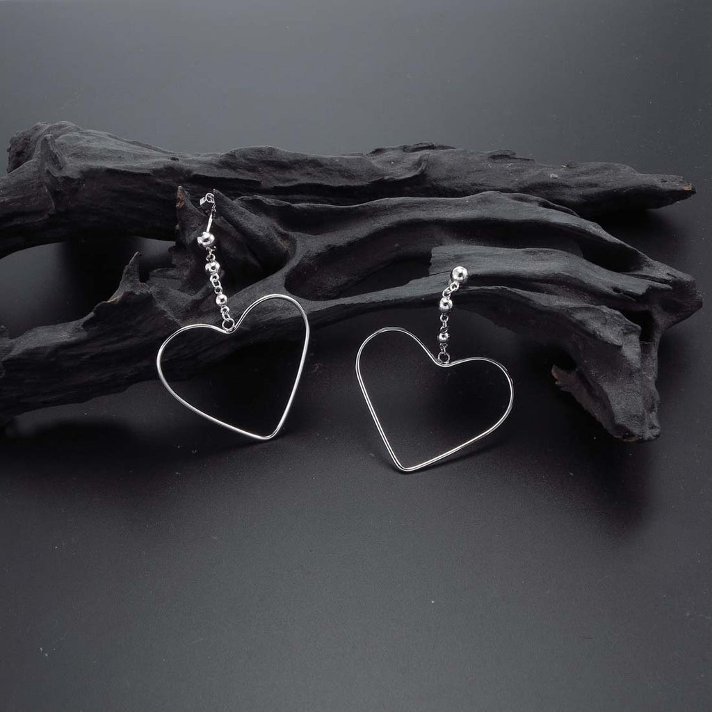 Hanging Heart Earrings in Sterling Silver on rocks