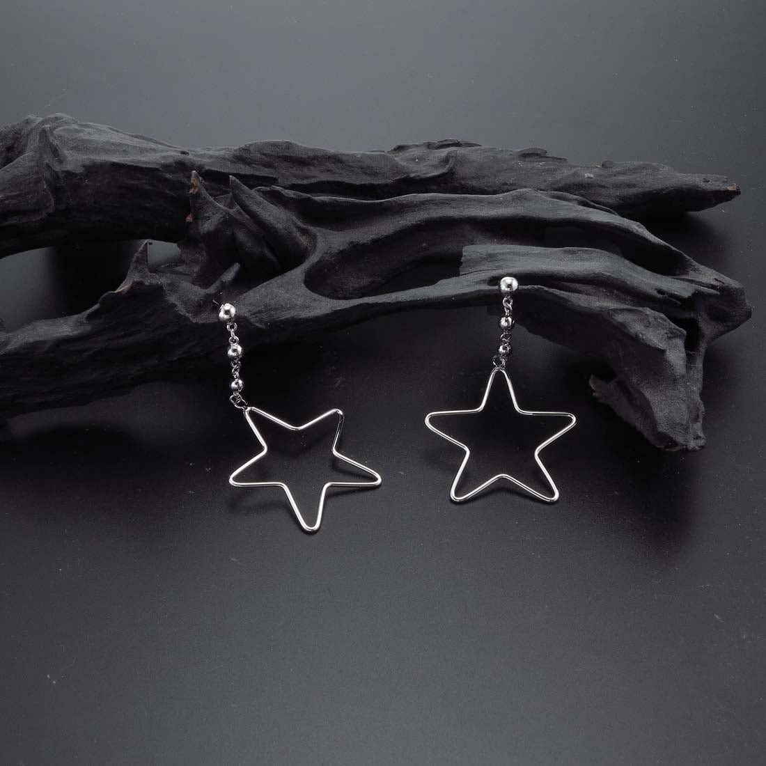 Hanging Star Earrings in Sterling Silver on rocks