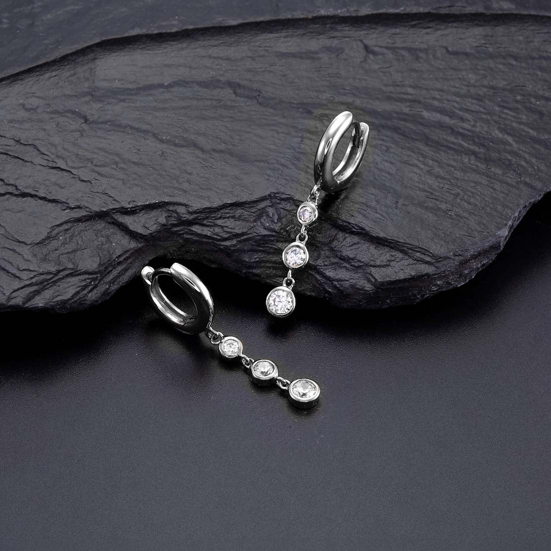 Trilogy Hoop Earrings with White Cubic Zirconia in Sterling Silver on rock