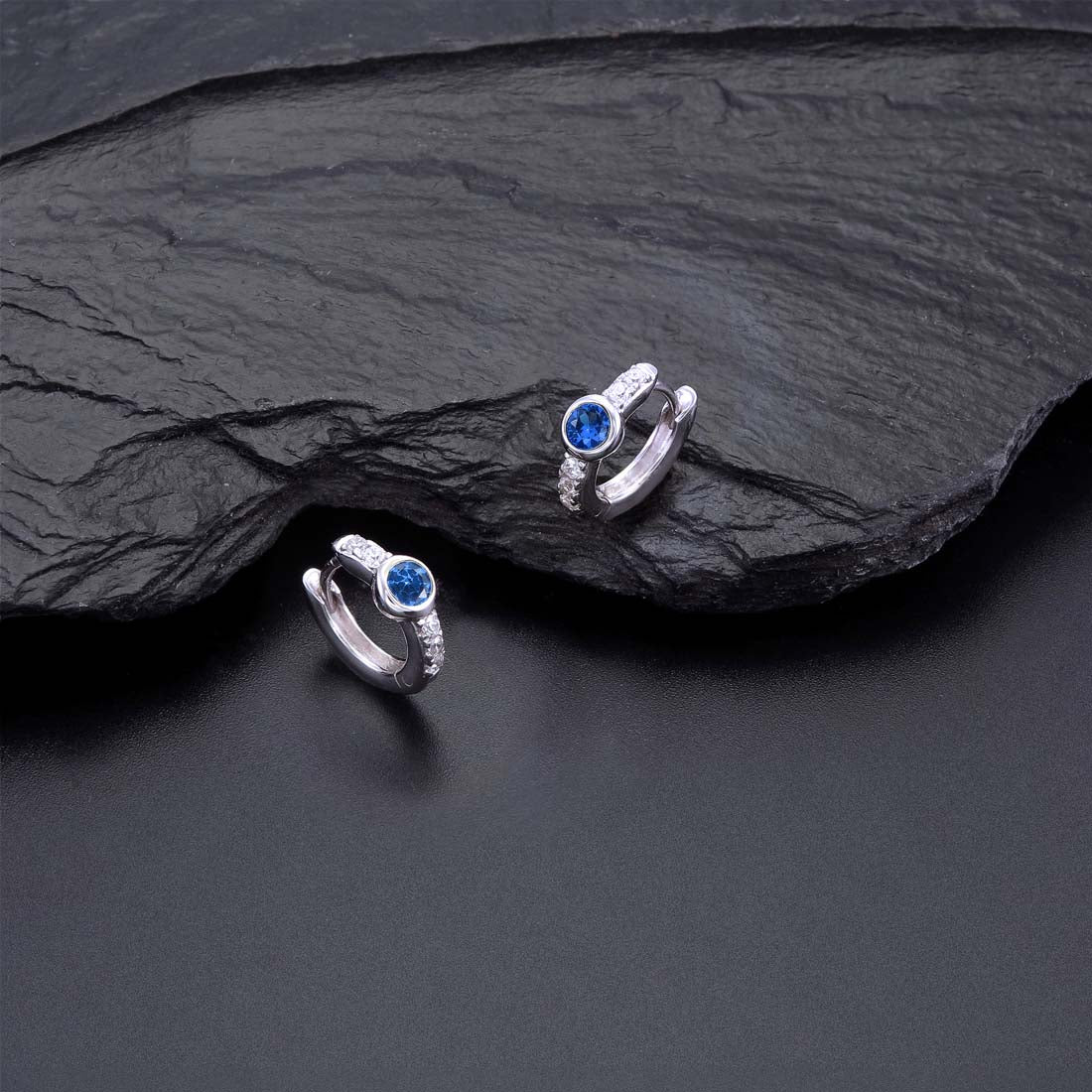 Bezel Blue Zirconia Hoop Earrings Cubic Zirconia in Sterling Silver on rocks