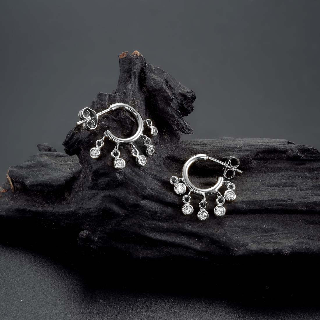 Mini Shaker Hoop Earrings with Cubic Zirconia in Sterling Silver on rocks
