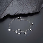 Sterling Silver Ladies Moon & Star Bracelet with Cubic Zirconia near black rock