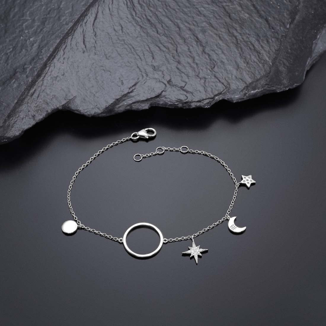 Sterling Silver Ladies Moon & Star Bracelet with Cubic Zirconia near black rock