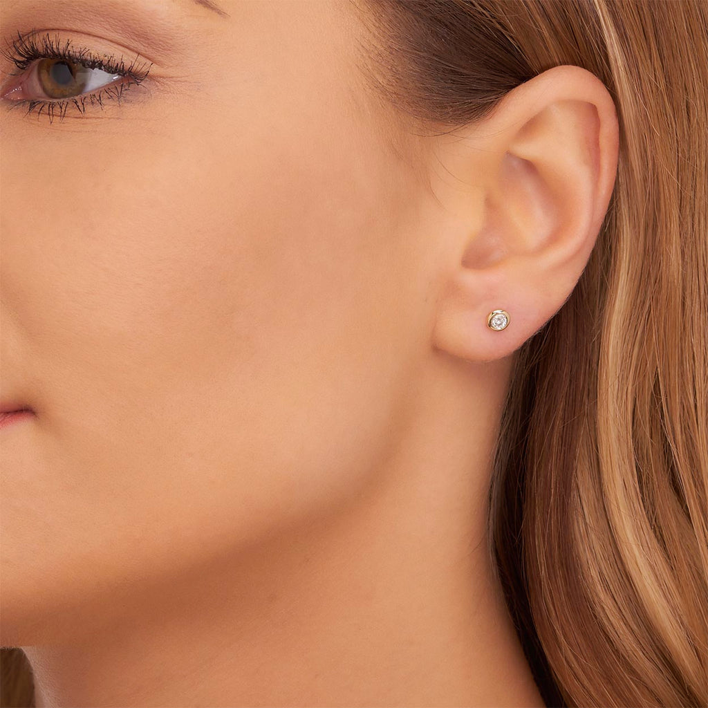 Solitaire 0.20ct Bezel set round diamond studs in 9K yellow gold