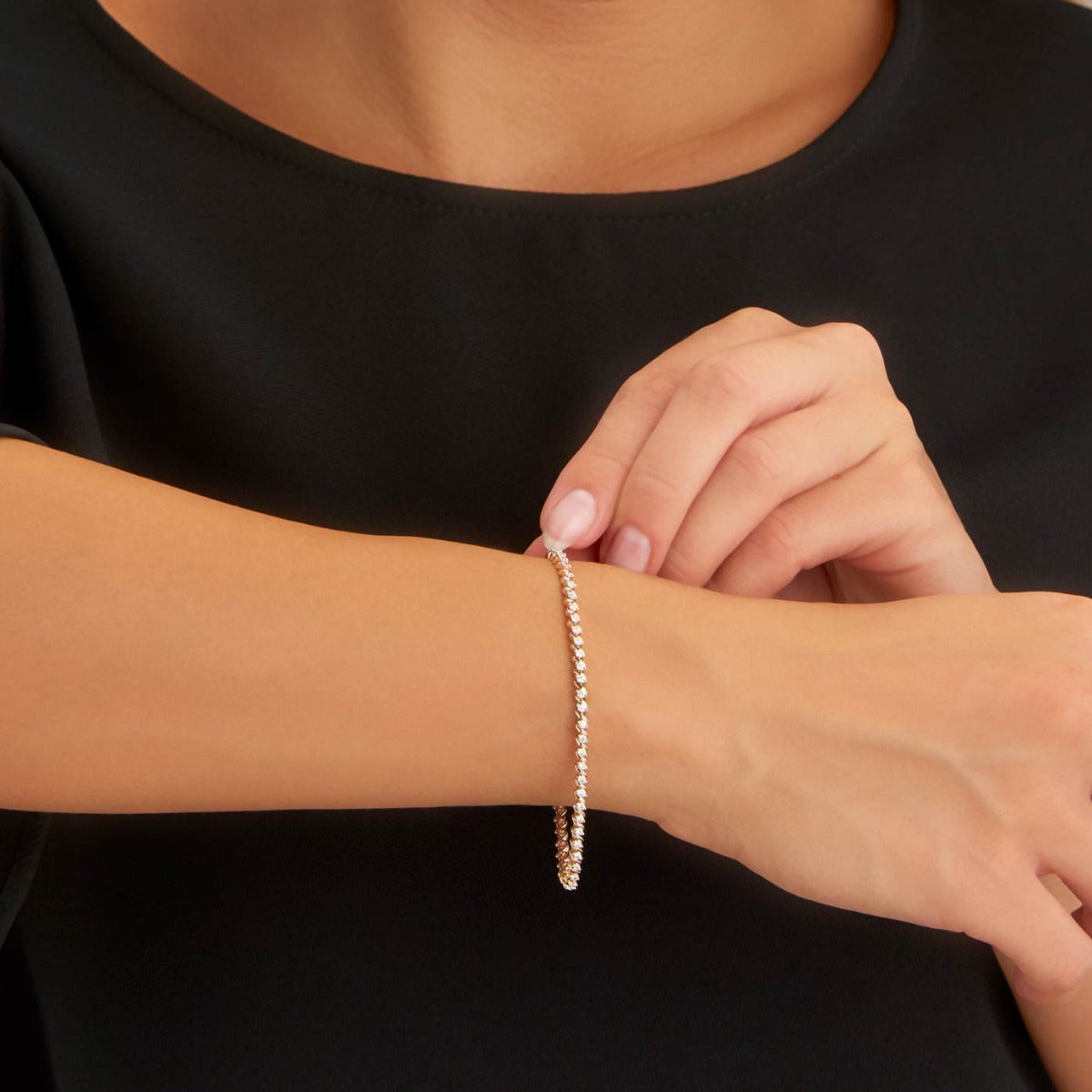Female Model Wearing Swirl Diamond Tennis Bracelet 1ct Diamonds in 9K Yellow Gold closeup