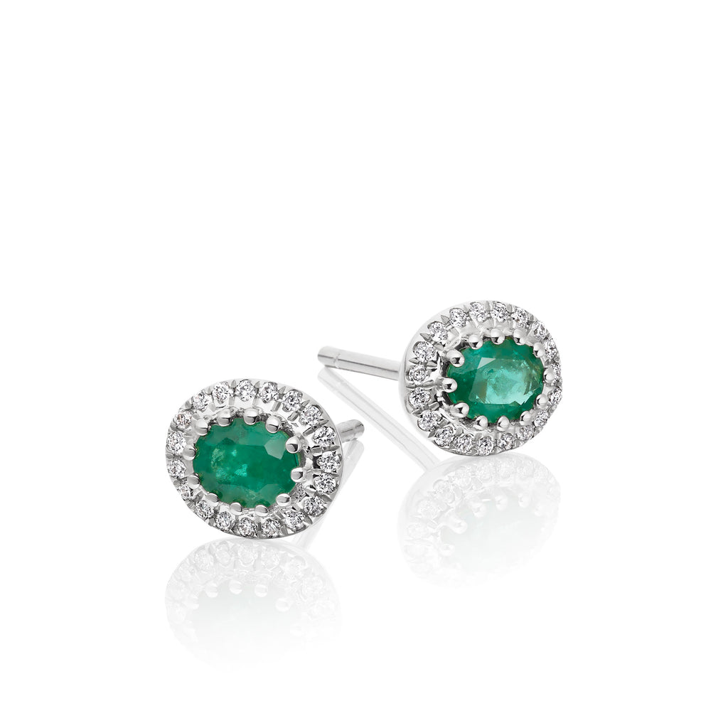 Oval Emerald and 0.11ct diamond stud earrings in 9K white gold