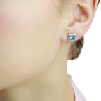 5mm x 5mm Blue Topaz and 0.19ct diamond stud earrings in 9K white gold